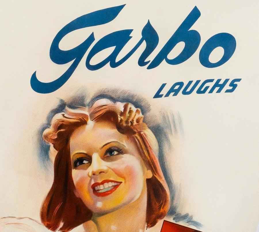 Vintage movie poster featuring smiling woman and bold text 'Garbo Laughs'